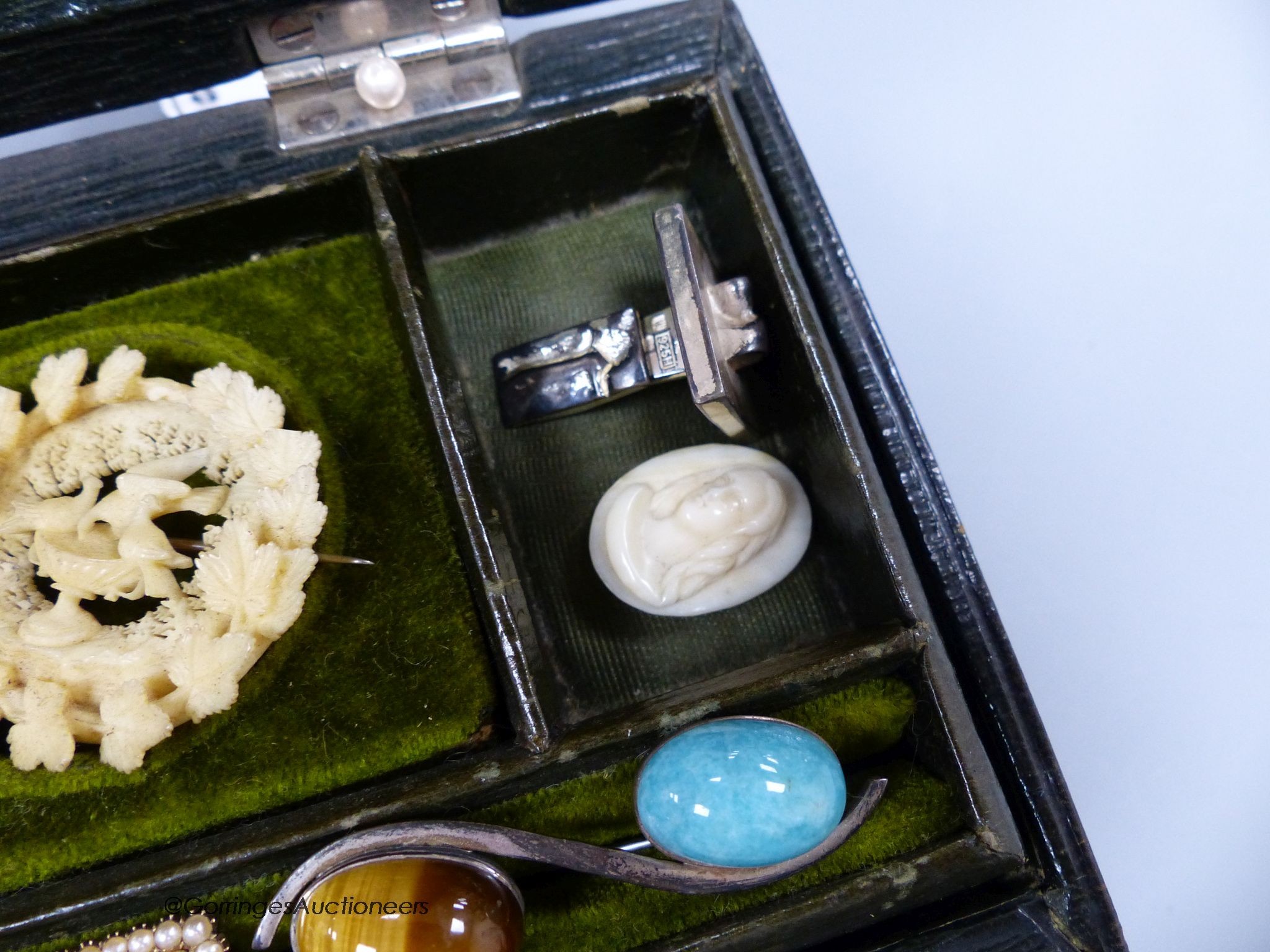 A small green leather jewellery box of assorted minor jewellery